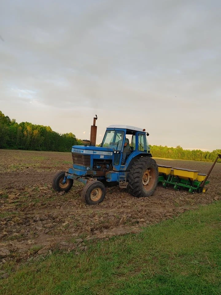 Ford tractor planting at dusk