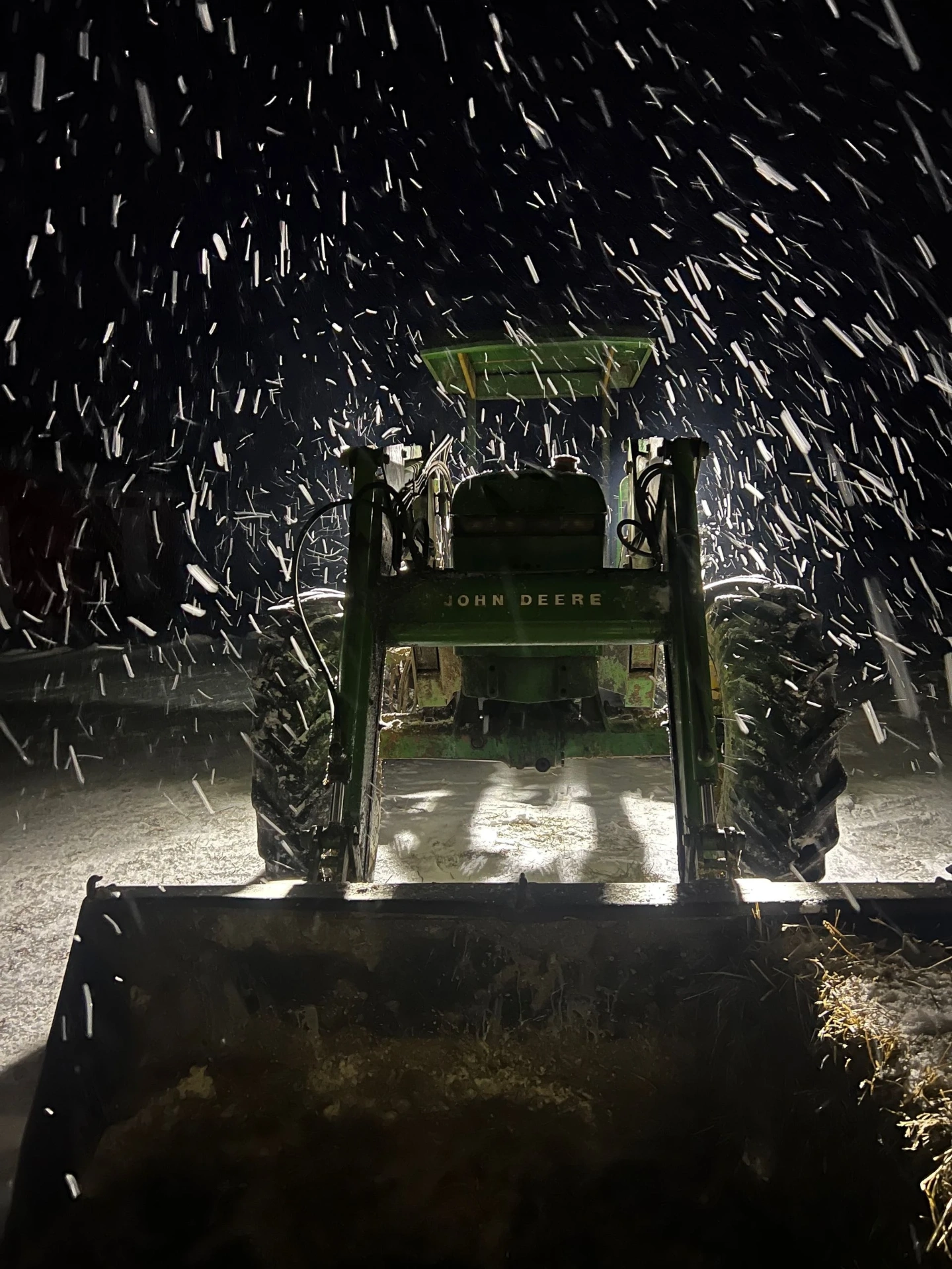 John Deere tractor in a snowstorm at night