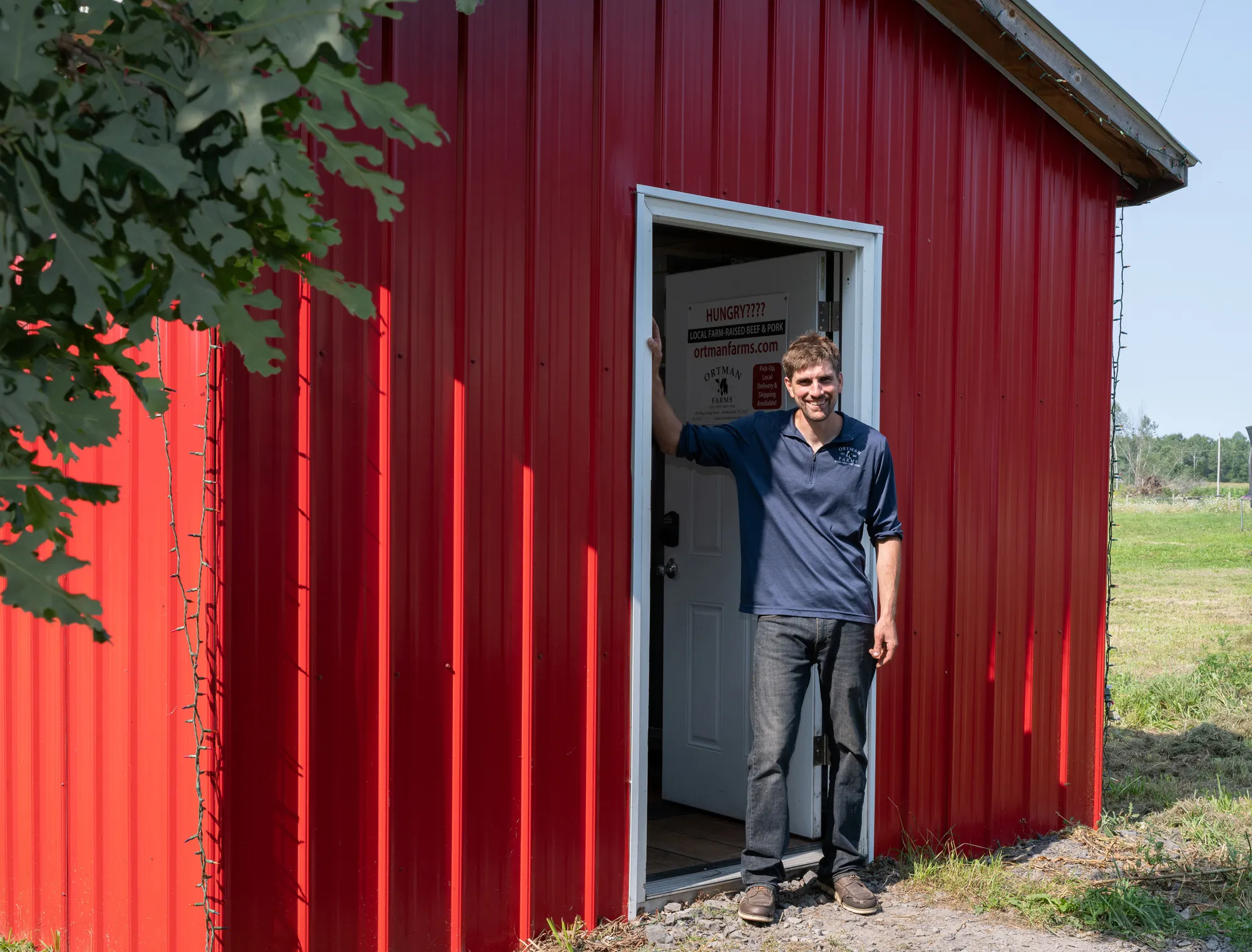 Michael at the farm's red barn and store