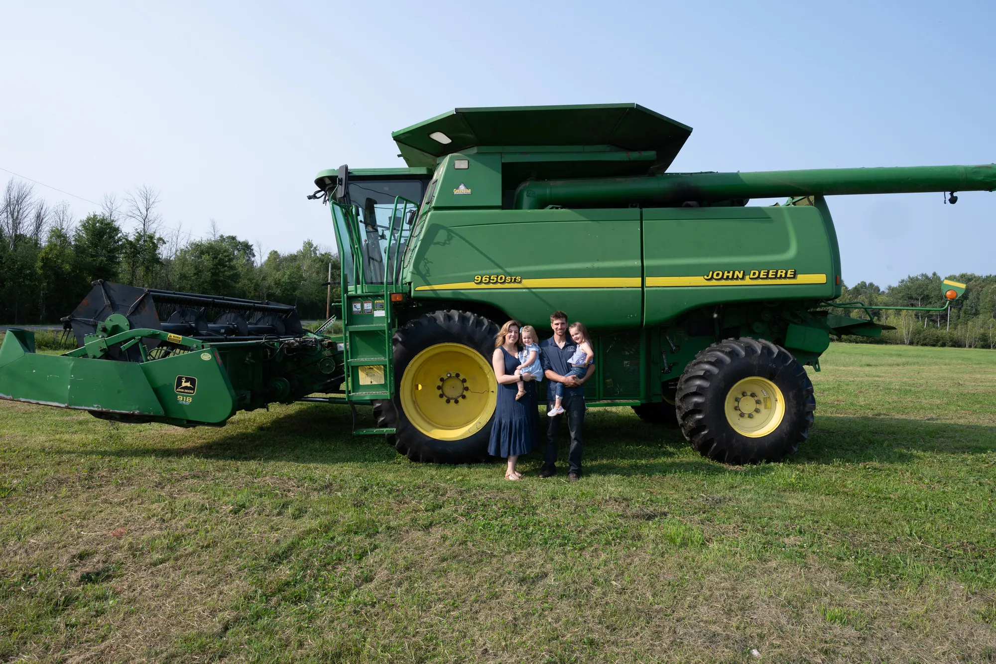 Ortman family with John Deere combine harvester