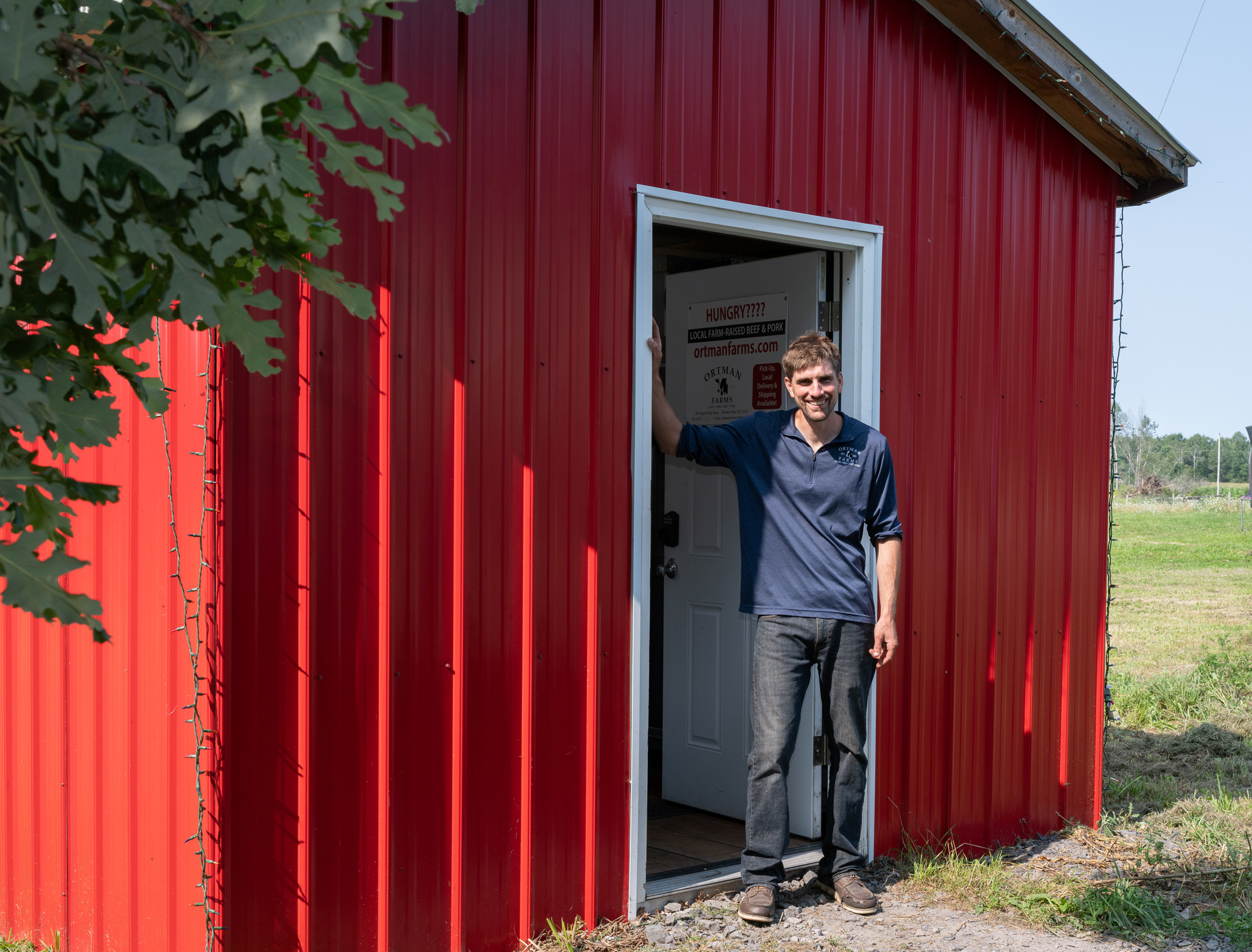Michael at the farm's red barn and store