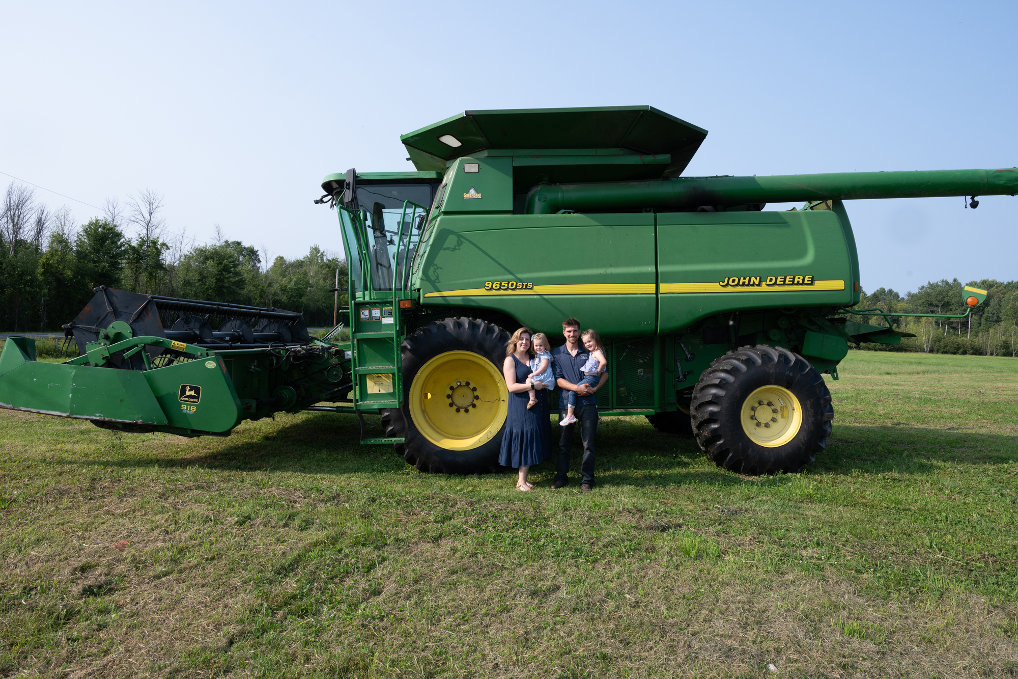 Ortman family with John Deere combine harvester